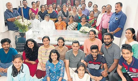 Photograph of a family posing beside a coffin that went viral on social media