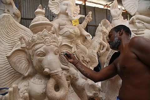 An artisan giving final touches to a Ganesha idol, at Mela Kondaiyampettai. | M K Ashok Kumar