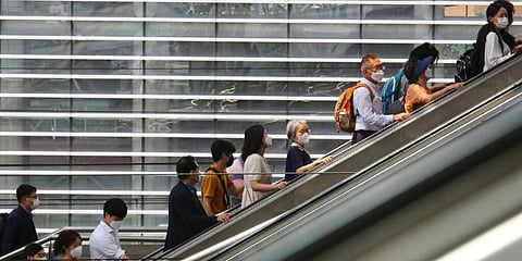 (Representational Image). People wearing face masks to help protect against the spread of the coronavirus ride an escalator at the Seoul Railway Station, South Korea. (Photo | AP)