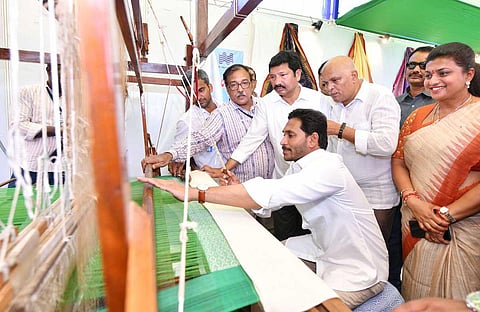 Chief Minister YS Jagan Mohan Reddy trying his hand at weaving at Pedana in Krishna on Thursday. He also interacted with beneficiaries of the scheme. (Photo | Express)