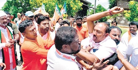 A TRS supporter tries to block BJP State president Bandi Sanjay from continuing his Praja Sangrama Yatra in Jangaon on Friday