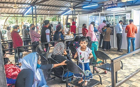People line up outside a facility on Capital Hospital premises to undergo antigen test