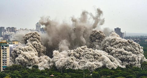 Pulverized concrete dust covers the neighbourhood after demolition of Supertech's twin towers in Noida, Sunday, Aug. 28, 2022. (Photo | PTI)