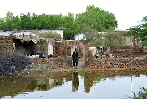 A man stand in front of his flood-hit home surrounded by water, in Jaffarabad, a district of Pakistan's southwestern Baluchistan province, Sunday, Aug. 28, 2022. (Photo | AP)