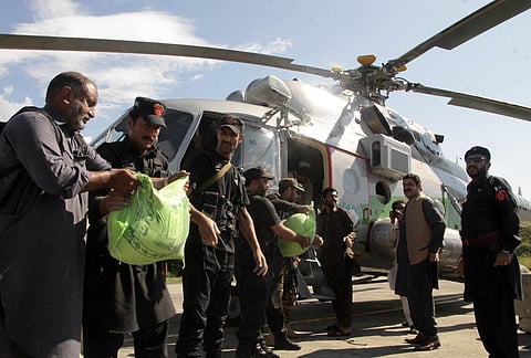 Frontier constabularies load food to a helicopter for flood-affected people, in Swat valley, Pakistan. (Photo | AP)