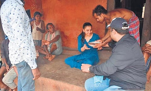 Collector Swadha Dev Singh being offered gruel in Lakhapadar village. (Photo | Express)