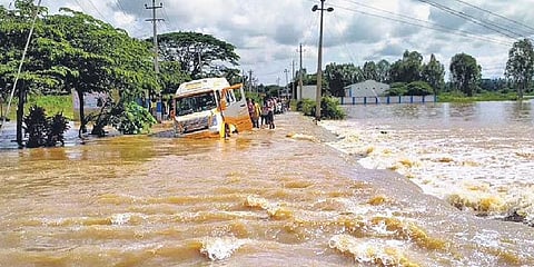 A van ploughs through a flooded road following heavy rain at Hosahalli Gate near Mandya on Tuesday. (Photo | KPN, EPS)