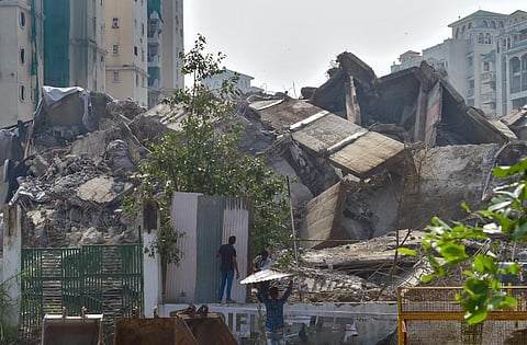 Labourers put up metal sheets to barricade the mound of debris of the demolished twin towers of Supertech, in Noida, Tuesday, Aug. 30, 2022.  (Photo | PTI)
