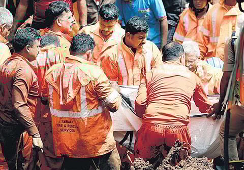 Rescue workers remove a body recovered from the debris following landslide at Sangamam in Kudayathoor, Idukki on Monday | Shiyami