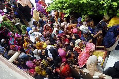 Flood affected people wait to receive for relief aid in Dadu district of Sindh Province in southern Pakistan (Photo | AP)