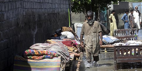 A man wade through a flooded area after heavy rains, in Charsadda, Pakistan on August 30, 2022. (Photo | AP)