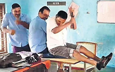 Employees with KSRTC bus station in Kochi enact a snakeboat race at their flooded office on Tuesday