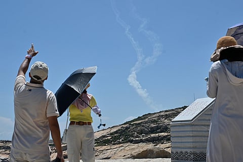 Smoke trails from projectiles launched by the Chinese military are seen as tourists look on from Pingtan island, one of mainland China's closest point from Taiwan. (Photo |AFP)