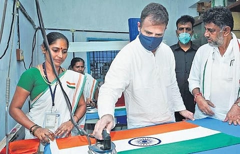 Congress MP Rahul Gandhi irons a Tricolour, as KPCC president DK Shivakumar looks on, at the KKGSS flag-making unit in Hubballi on Wednesday .(Photo| D Hemanth, EPS)