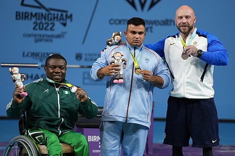 India's Sudhir, center, Nigeria's Ikechukwu Obichukwu, left, and Scotland's Micky Yule pose with their gold, silver and bronze medals respectively. (Photo | AP)