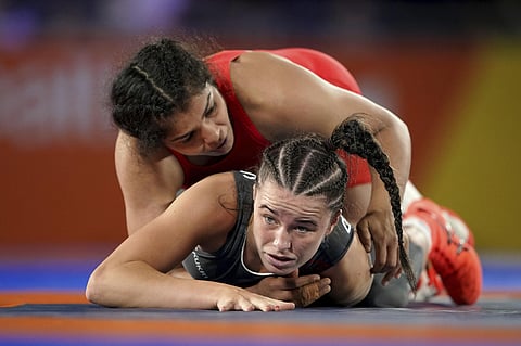 England's Kelsey Barnes grapples with Indian wrestler Sakshi Malik (top) during the 62kg bout at the Commonwealth Games on Friday (AP)