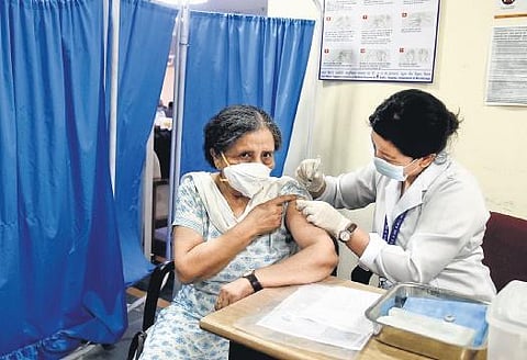 A health worker administers a Covid-19 dose to an elderly woman. (Photo | EPS)