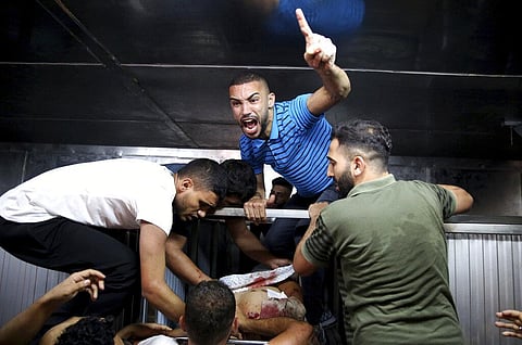 Mourners chant Islamic slogans at Shifa morgue next to the body of Taiseer al-Jabari, Islamic Jihad commander, who was killed during Israeli airstrikes on his apartment in Gaza City. (Photo | AP)