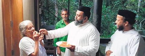 Father Shibin Paul offers sweets to Eldhose Paul’s grandmother Mariyamma at Pampakuda in Ernakulam, Kerala, on August 7, 2022. (Photo | EPS)
