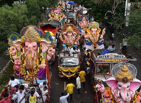 A massive procession of Ganesh idols passes through NTR Marg in Hyderabad on Saturday; (right) GHMC workers clear the remnants of Ganesh idols after the immersion with the help of cranes at Kapra lake