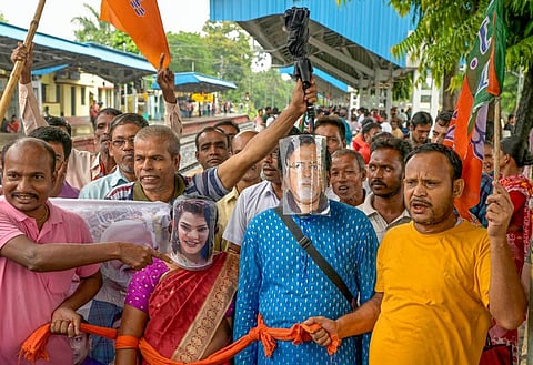 BJP supporters wearing masks of former WB minister Partha Chatterjee and his aide Arpita Mukherjee, gather to board a Sealdah-bound train to participate in the party's 'Nabanna Abhijan'. (Photo | PTI)