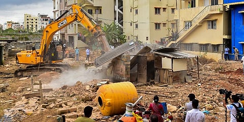 A Bruhat Bengaluru Mahanagara Palike (BBMP) bulldozer demolishes an illegal structure built on storm-water drain in Munnekolala area. (Photo | PTI)