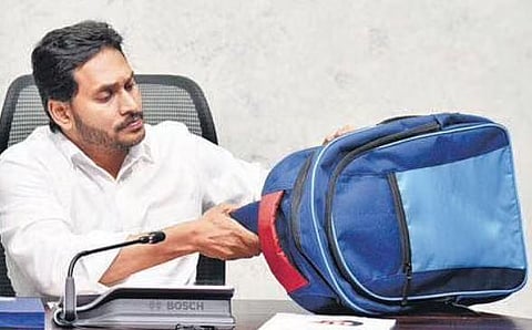 Chief Minister YS Jagan Mohan Reddy examines a schoolbag at a review meeting at his camp office in Tadepalli on Monday | Express