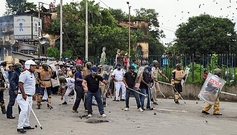 Security personnel attempt to disperse BJP supporters from the Howrah Bridge during their 'Nabanna Abhijan' (March to Secretariat) protest. (Photo | PTI)