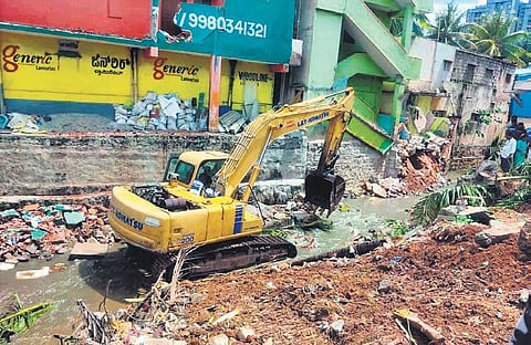 An earthmover clears encroachments from a storm water drain at Dasarahalli