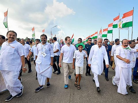 Congress leader Rahul Gandhi walks with a young supporter during party's 'Bharat Jodo Yatra' in Kerala. (Photo | PTI)