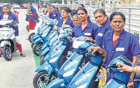 Safai karmacharis working in Vidhana and Vikasa soudhas pose with the electric bikes given to them by the government, on Friday | Shashidhar Byrappa