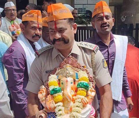 Police Inspector J M Kalimirchi carrying a Ganesha statue during the installation day on Gokul Road. (Photo | EPS)