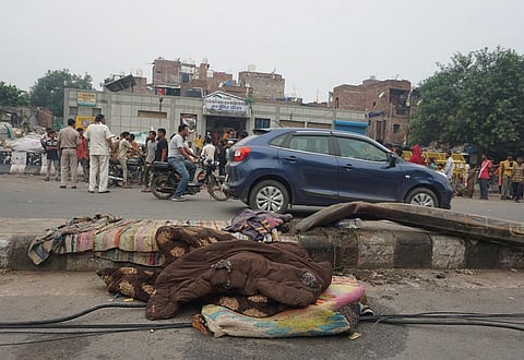 Rugs and blankets belonging to homeless people lie on a road, after a speeding truck mowed down people sleeping on a road divider at Seemapuri area, in New Delhi, Wednesday. (Photo | PTI)