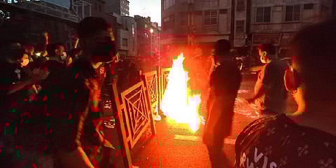 Protesters make fire and block the street during a protest over the death of a woman who was detained by the morality police, in downtown Tehran, Iran. (Photo | AP)