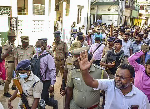 Members of Social Democratic Party of India (SDPI) raise slogans as police personnel escort officers of National Investigation Agency (NIA), in Madurai. (Photo | PTI)