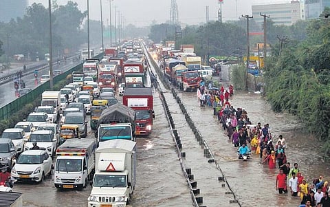 (Left) Students caught in the rain near Mandir Marg on Thursday, and commuters wade through a waterlogged Delhi-Gurugram Expressway | Parveen Negi & PTI