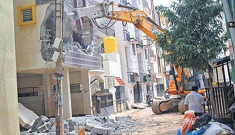 A one-storey building which encroaches a storm water drain being demolished, in Shantiniketan Layout of Munnekolala on Thursday | Vinod Kumar T