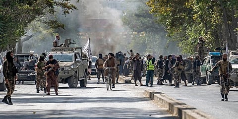 Taliban fighters stand guard at the explosion site, near a mosque, in Kabul, Afghanistan, Friday. (Photo |AP)