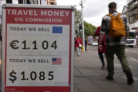 Pedestrians pass a currency exchange sign outside a shop in London, Sept. 23, 2022. (Photo | AP)