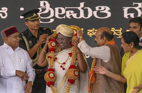President Droupadi Murmu being presented Mysore 'peta' by Karnataka CM Basavaraj Bommai during the inauguration of the Mysuru Dasara Festival, at Chamundi Hills in Mysuru on Monday. (Photo | PTI)