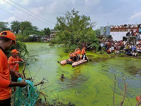 SDRF personnel conduct a rescue and relief operation after a tractor trolley overturned and fell into a pond, at Itaunja police station area in Lucknow. (Photo | PTI)