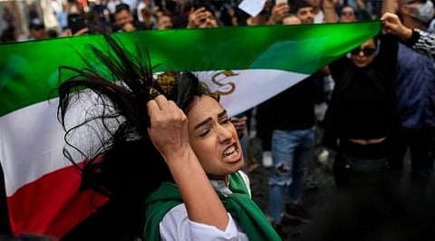 A woman shouts slogans next to an Iranian flag during a protest against the death of Iranian Mahsa Amini, outside Iran’s general consulate in Istanbul, Turkey, Sept. 21, 2022. (Photo | AP)