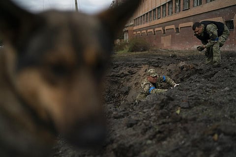 Ukrainian police officers collect fragments from a crater to determine the type of ammunition after a Russian attack in Kramatorsk, Ukraine, Thursday, Sept. 29, 2022. (Photo | AP)
