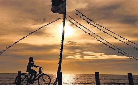 A man cycles past a PFI flagmast at Kothi beach in Kozhikode as the sun sets on Thursday | E Gokul