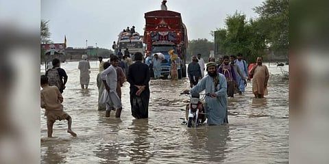 People navigate through a flooded road caused by heavy monsoon rains, in Nasirabad, a district of Pakistan's southwestern Baluchistan province. (Photo | AP)
