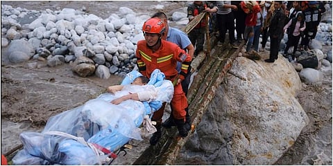 Rescuers transfer survivors across a river following an earthquake in Moxi Town of Luding County, southwest China's Sichuan Province on Monday. (Photo | AP)