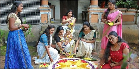 A family creating a beautiful flower carpet in front of their house for Onam. (Photo | EPS)
