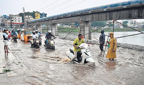 Motorists wade through the flooded Moosarambagh bridge in Hyderabad on Wednesday