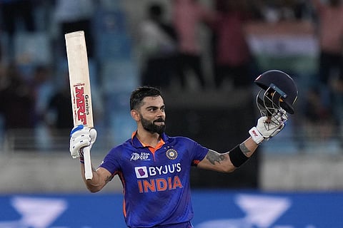 Virat Kohli raises his bat and helmet to celebrate scoring a century during T20 cricket match of Asia Cup between India and Afghanistan, in Dubai on Thursday. (Photo | PTI)