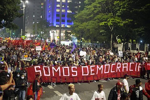 Demonstrators march holding a banner that reads in Portuguese 'We are Democracy' during a protest calling for protection of Brazil's democracy in Sao Paulo, Jan. 9, 2023. (Photo | AP)